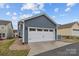 Attached two-car garage with a white door and ample parking space in the driveway at 12545 Druids Glen Dr, Pineville, NC 28134