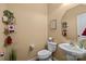 Powder room featuring pedestal sink, toilet, and decorative shelving at 12545 Druids Glen Dr, Pineville, NC 28134