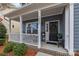 Inviting porch with floral wreath, flowers and cozy seating at 12545 Druids Glen Dr, Pineville, NC 28134