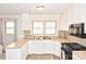 Bright kitchen featuring white cabinets, laminate countertops, and modern appliances at 1404 Lane Rd, Mount Holly, NC 28120