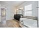 Bright bathroom boasts double sink vanity, soaking tub, and leads to main bedroom at 14920 High Bluff Ct, Charlotte, NC 28278