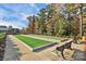 Enjoy the outdoor Bocce Ball Courts set within a picturesque landscape with mature trees on a sunny day at 14920 High Bluff Ct, Charlotte, NC 28278