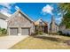 Charming stone-accented home with a manicured lawn and two-car garage under a beautiful blue sky at 14920 High Bluff Ct, Charlotte, NC 28278