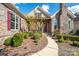 Inviting home facade with stone details, colorful shutters, manicured shrubs and walkway to entrance at 14920 High Bluff Ct, Charlotte, NC 28278