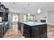 Open kitchen with granite island, stainless appliances, and hardwood floors, leading to a cozy living space at 14920 High Bluff Ct, Charlotte, NC 28278