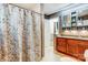 Bathroom featuring wood cabinetry, a shower with decorative curtain, and coordinated fixtures, offering functionality at 1625 Saint Paul Church Rd, Salisbury, NC 28146