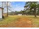 Expansive backyard with grass, outbuildings, and trees beneath a partly cloudy sky at 1641 Knoll Dr, Vale, NC 28168