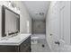 Well-lit bathroom featuring a stylish vanity, a tub with gray tiling, and tiled floors at 1641 Knoll Dr, Vale, NC 28168