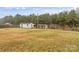 View of outbuildings in the back of the property with trees under a partly cloudy sky at 1641 Knoll Dr, Vale, NC 28168
