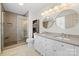 Modern bathroom featuring a glass shower, double vanity with modern fixtures and round mirrors at 16417 Grapperhall Dr, Huntersville, NC 28078