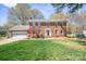 Charming two-story brick home with lush green lawn and mature trees, offering classic curb appeal at 16417 Grapperhall Dr, Huntersville, NC 28078