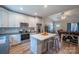 Open kitchen with white cabinets, stainless appliances, island with seating, and open to the living room at 1700 Ivey Ct, Maiden, NC 28650