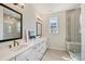Bathroom features dual vanities, quartz countertops, and tiled shower with glass door at 208 Emerson Ave, Charlotte, NC 28204