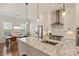 Well-lit kitchen features granite countertops, stainless appliances, and breakfast area with chandelier at 208 Emerson Ave, Charlotte, NC 28204