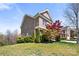 Beautiful landscaped yard of a two-story brick home featuring mature trees and lush greenery at 2251 Barrowcliffe Nw Dr, Concord, NC 28027