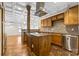 Kitchen featuring tiled backsplash, granite countertops, wooden cabinets, and an island with an overhead vent at 2251 Barrowcliffe Nw Dr, Concord, NC 28027