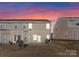Backyard view featuring a small patio with seating, at dusk with a colorful sunset sky at 2259 Crosscut Dr, Charlotte, NC 28214