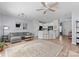 Open concept living room featuring a ceiling fan, sofa, and view of the kitchen with a breakfast bar at 2259 Crosscut Dr, Charlotte, NC 28214