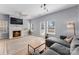 Bright living room features a fireplace, ceiling fan, wood floors, and natural light from multiple windows at 2259 Crosscut Dr, Charlotte, NC 28214