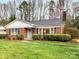 Charming brick home featuring a manicured lawn, quaint landscaping, and a bright blue front door at 2908 Enfield Rd, Charlotte, NC 28205