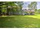 Expansive backyard with a well-maintained lawn, mature trees, and a convenient covered parking area at 3400 Tracelake Dr, Matthews, NC 28105