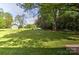 Expansive, lush backyard featuring a well-maintained lawn and mature trees, perfect for outdoor activities at 3400 Tracelake Dr, Matthews, NC 28105