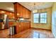 Bright and airy dining area with traditional wood cabinetry, chandelier lighting, and large windows offering backyard views at 3400 Tracelake Dr, Matthews, NC 28105