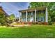 Charming two-story home featuring a well-manicured lawn and inviting front porch with classic white columns at 3400 Tracelake Dr, Matthews, NC 28105