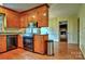 A well-equipped kitchen featuring wood cabinets and black appliances, connected to a dining area for easy entertaining at 3400 Tracelake Dr, Matthews, NC 28105
