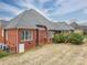 This home has a brick exterior, well-maintained lawn, mature shrubbery, a screened in porch and a gray roof at 3516 Araglin Dr, Gastonia, NC 28056
