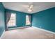 Cozy bedroom with blue walls, neutral carpet, and a ceiling fan with an integrated lighting fixture at 3516 Araglin Dr, Gastonia, NC 28056