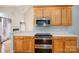 Stylish kitchen with stainless steel oven and stovetop, wood cabinetry, and neutral backsplash at 3516 Araglin Dr, Gastonia, NC 28056