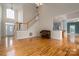 Open-concept living room with hardwood floors, staircase, and piano at 3516 Araglin Dr, Gastonia, NC 28056