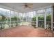 Relax in this spacious screened porch featuring brick flooring, a ceiling fan and views of the lush backyard at 3516 Araglin Dr, Gastonia, NC 28056