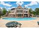 Resort-style pool with an expansive deck, lounge chairs, and a two-story clubhouse in the background at 4036 Sawmill Trace Dr, Charlotte, NC 28213