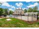 Community pool and patio area with a white pergola, lush grass, and a black fence at 4036 Sawmill Trace Dr, Charlotte, NC 28213