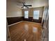 Bedroom with two windows, hardwood floors, two-tone walls, and a ceiling fan for optimal lighting at 4210 Runaway Cir, Monroe, NC 28110