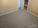 Neutral bedroom showcasing plush carpeting and a view to the upstairs hallway at 4210 Runaway Cir, Monroe, NC 28110
