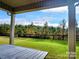 A view of the private backyard, grassy area, and fence line is viewed from the covered back patio at 4253 Stream Dale Nw Cir, Concord, NC 28027