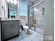 Neutral-toned bathroom features a tile shower with glass door, tile floor, and granite countertop at 4253 Stream Dale Nw Cir, Concord, NC 28027