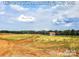 A view of open grassy community land with treelines and a shed under a partly cloudy sky in 2019 at 4253 Stream Dale Nw Cir, Concord, NC 28027