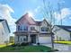 Inviting two-story home with stone and siding exterior, a manicured lawn, and a sunny sky at 4253 Stream Dale Nw Cir, Concord, NC 28027