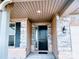 Covered front porch with stone details and a stylish black front door at 4253 Stream Dale Nw Cir, Concord, NC 28027