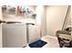 Efficient laundry area with a washer, dryer, wire shelving, and blue rug on tile flooring at 4253 Stream Dale Nw Cir, Concord, NC 28027