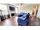 Open-concept living room featuring a fireplace, large TV, and comfortable blue sectional sofa at 4253 Stream Dale Nw Cir, Concord, NC 28027