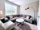Stylish living room features a modern sectional sofa, accent pillows, and lots of light at 4253 Stream Dale Nw Cir, Concord, NC 28027