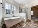 Bright bathroom features a sleek soaking tub, glass-enclosed shower, and wood-look flooring at 4262 Brandy Creek Ct, Clover, SC 29710