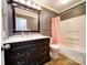 The bathroom includes dark vanity, marble countertop, framed mirror, shower and hardwood floors at 4401 Coachwood Ln, Gastonia, NC 28056