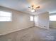 Bedroom features neutral walls, carpet, two windows, and a ceiling fan at 4401 Coachwood Ln, Gastonia, NC 28056