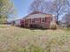 A lovely brick home featuring a red roof and shutters, set on a well-maintained lawn at 4401 Coachwood Ln, Gastonia, NC 28056
